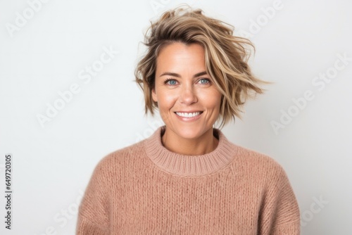 portrait of a confident Polish woman in her 30s wearing a cozy sweater against a white background
