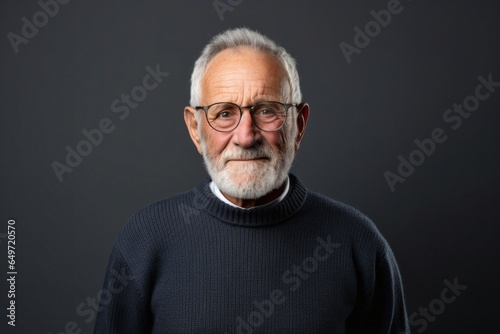 Portrait of a Israeli man in his 70s wearing a cozy sweater against a white background