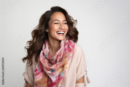 Portrait of a confident Filipino woman in her 30s wearing a foulard against a white background