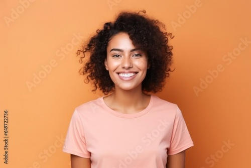 medium shot portrait of a confident Mexican woman in her 20s wearing a casual t-shirt against an abstract background