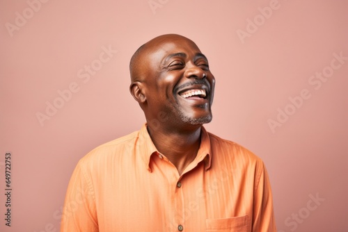 Portrait of a confident Kenyan man in his 50s wearing a chic cardigan against a pastel or soft colors background