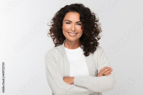 medium shot portrait of a confident Mexican woman in her 40s wearing a chic cardigan against a white background