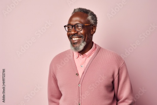 Portrait of a confident Kenyan man in his 50s wearing a chic cardigan against a pastel or soft colors background © Anne-Marie Albrecht