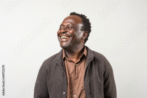 Portrait of a confident Kenyan man in his 40s wearing a chic cardigan against a white background