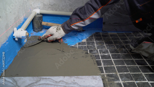 Floor renovation, ceramic tile adhesive application. Laying ceramic tiles on old tiles. Floor renovation.