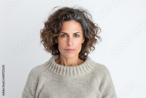 medium shot portrait of a serious, Israeli woman in her 40s wearing a cozy sweater against a white background © Leon Waltz