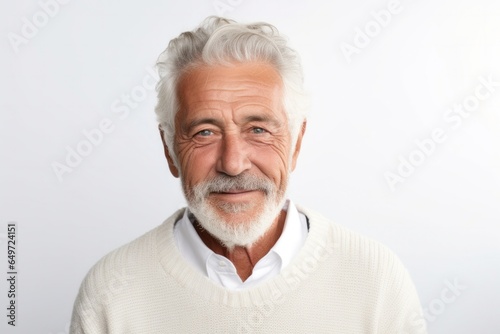 medium shot portrait of a Israeli man in his 60s wearing a chic cardigan against a white background © Leon Waltz