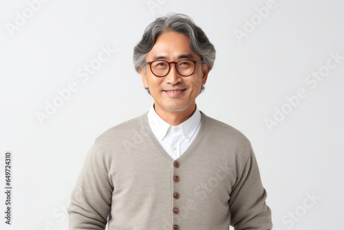 medium shot portrait of a happy Japanese man in his 40s wearing a chic cardigan against a white background