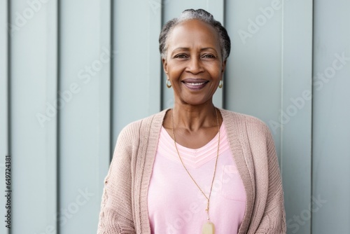 medium shot portrait of a Kenyan woman in her 50s wearing a chic cardigan against a white background