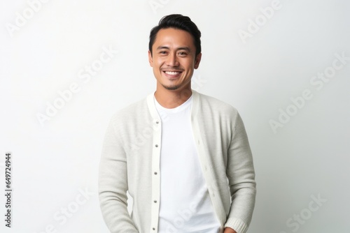 medium shot portrait of a happy Filipino man in his 30s wearing a chic cardigan against a white background photo