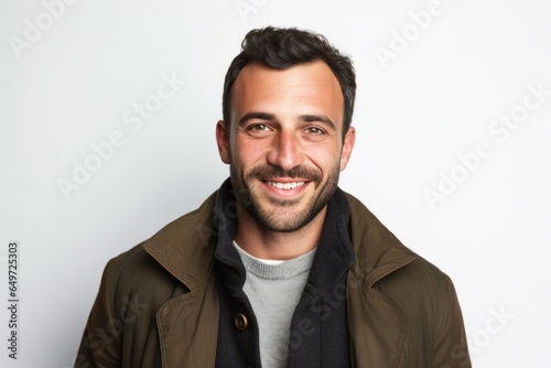 medium shot portrait of a happy Israeli man in his 30s wearing a chic cardigan against a white background © Anne-Marie Albrecht