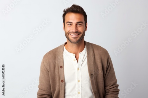 medium shot portrait of a happy Israeli man in his 30s wearing a chic cardigan against a white background
