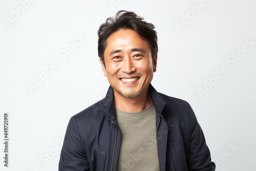 medium shot portrait of a happy Japanese man in his 40s wearing a chic cardigan against a white background