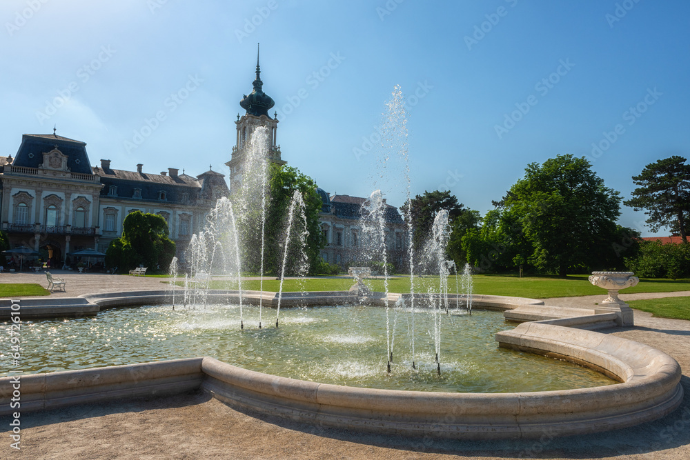 Festetics palace with beautiful garden and exquisite fountain on sunny summer day, baroque architecture, Keszthely, Zala, Hungary. Outdoor travel background
