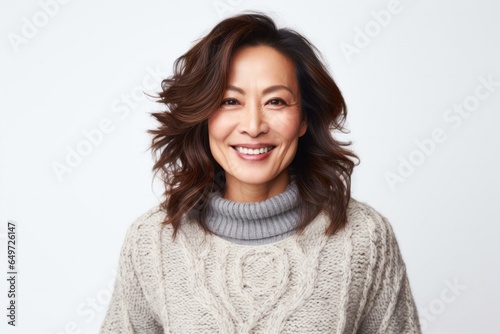 medium shot portrait of a happy Japanese woman in her 40s wearing a cozy sweater against a white background © Anne-Marie Albrecht
