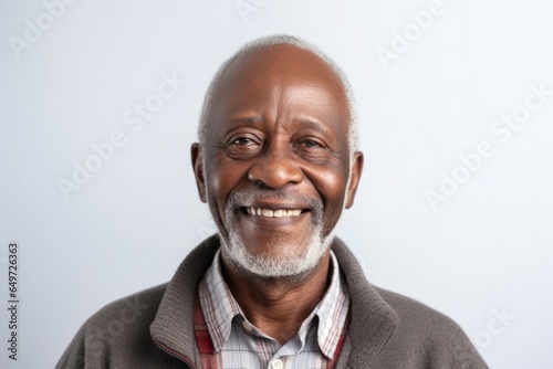 medium shot portrait of a happy Kenyan man in his 60s wearing a chic cardigan against a white background