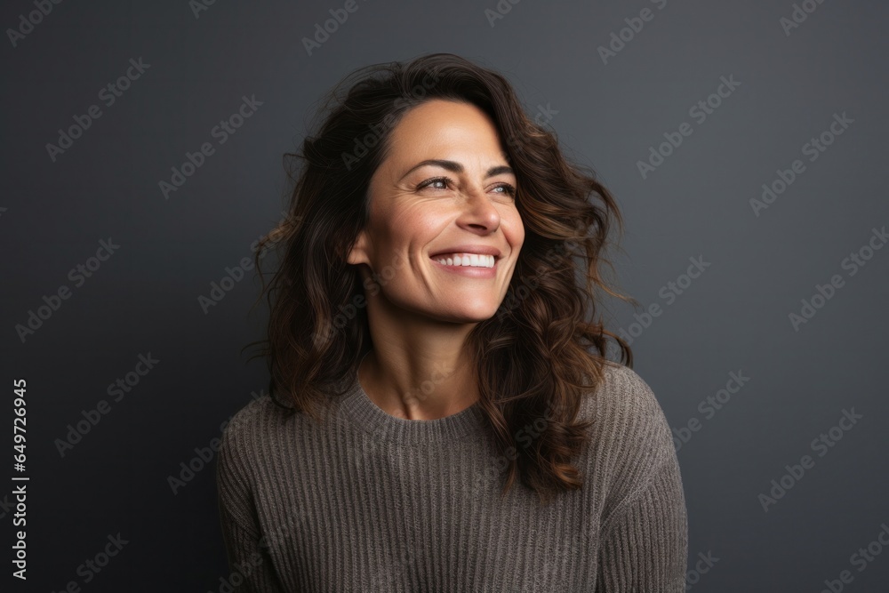 portrait of a happy Israeli woman in her 40s wearing a cozy sweater against a minimalist or empty room background portrait of a happy Israeli woman in her 40s wearing a cozy sweater against a minimalist or empty room background
