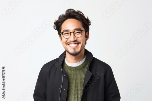 portrait of a happy Japanese man in his 30s wearing a chic cardigan against a white background
