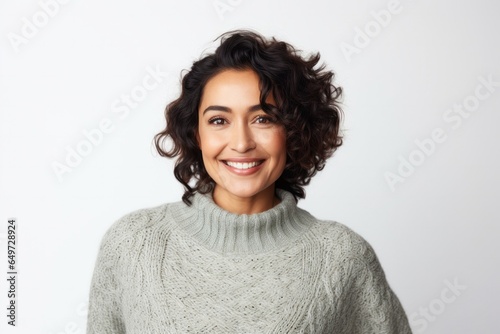portrait of a happy Mexican woman in her 40s wearing a cozy sweater against a white background
