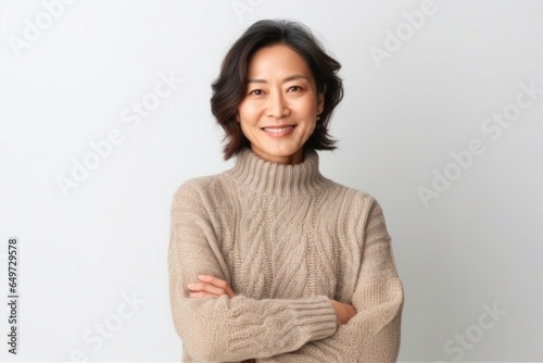 medium shot portrait of a Japanese woman in her 40s wearing a cozy sweater against a white background