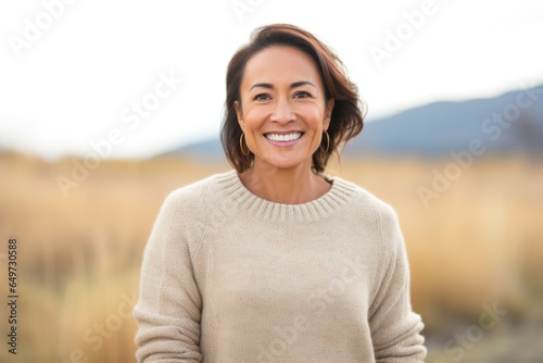 portrait of a Filipino woman in her 40s wearing a cozy sweater against a white background