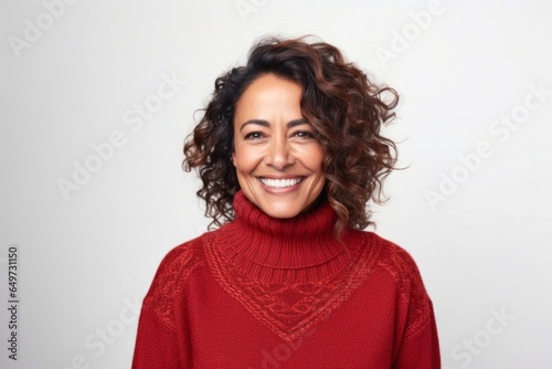medium shot portrait of a Mexican woman in her 40s wearing a cozy sweater against a white background © Anne-Marie Albrecht