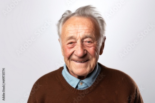 medium shot portrait of a Polish man in his 80s wearing a chic cardigan against a white background