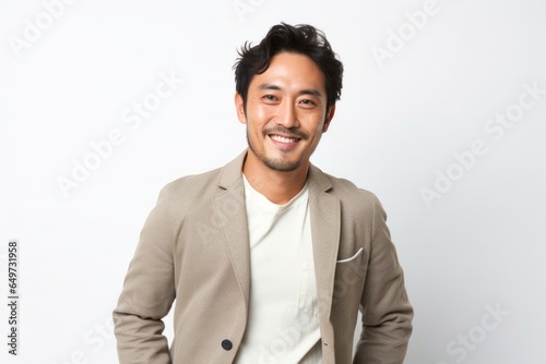 portrait of a Japanese man in his 30s wearing a chic cardigan against a white background