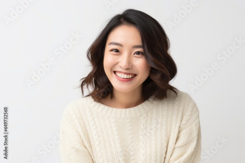 portrait of a Japanese woman in her 30s wearing a cozy sweater against a white background