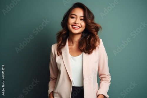 medium shot portrait of a confident Filipino woman in her 30s wearing a classic blazer against an abstract background