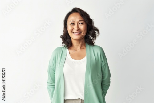 medium shot portrait of a confident Filipino woman in her 40s wearing a chic cardigan against a white background