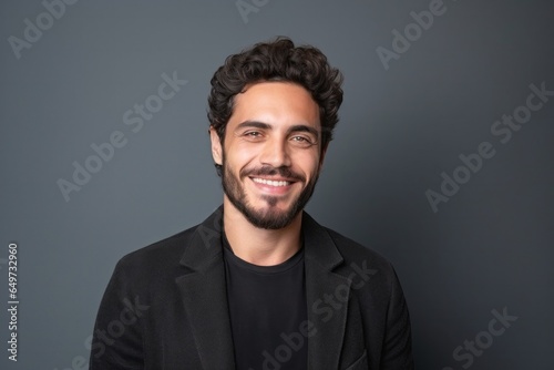 medium shot portrait of a confident Israeli man in his 20s wearing a chic cardigan against a minimalist or empty room background