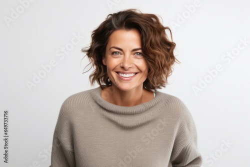 medium shot portrait of a confident Israeli woman in her 40s wearing a cozy sweater against a white background © Anne-Marie Albrecht