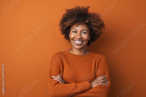 portrait of a Kenyan woman in her 30s wearing a cozy sweater against an abstract background