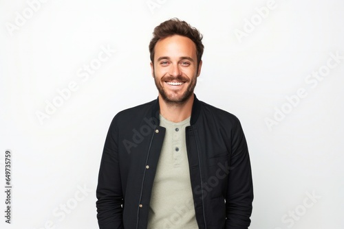 portrait of a Polish man in his 30s wearing a chic cardigan against a white background