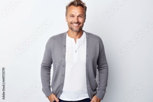 portrait of a Polish man in his 30s wearing a chic cardigan against a white background