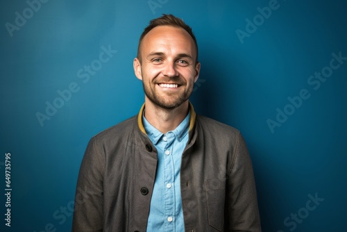 portrait of a Polish man in his 30s wearing a chic cardigan against an abstract background