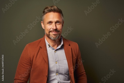 portrait of a Polish man in his 40s wearing a chic cardigan against an abstract background