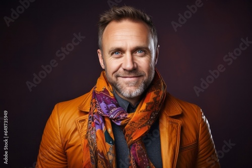 portrait of a Polish man in his 40s wearing a foulard against an abstract background