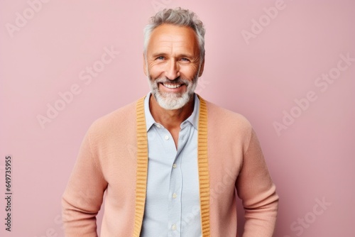portrait of a Polish man in his 50s wearing a chic cardigan against a pastel or soft colors background