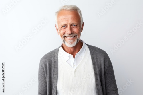 portrait of a Polish man in his 50s wearing a chic cardigan against a white background
