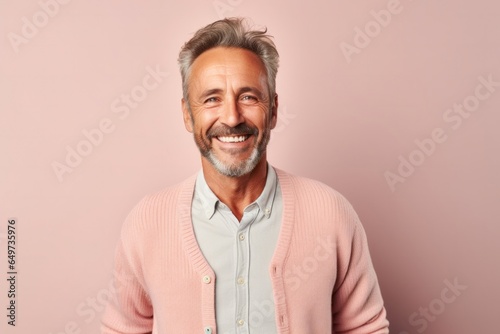 portrait of a Polish man in his 50s wearing a chic cardigan against a pastel or soft colors background