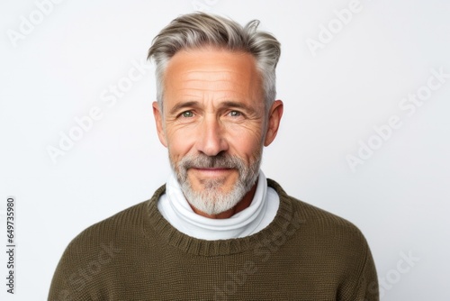 portrait of a Polish man in his 50s wearing a chic cardigan against a white background
