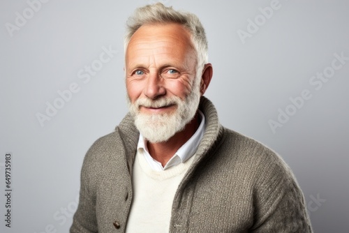 portrait of a Polish man in his 50s wearing a chic cardigan against a white background