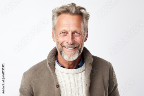 portrait of a Polish man in his 50s wearing a chic cardigan against a white background