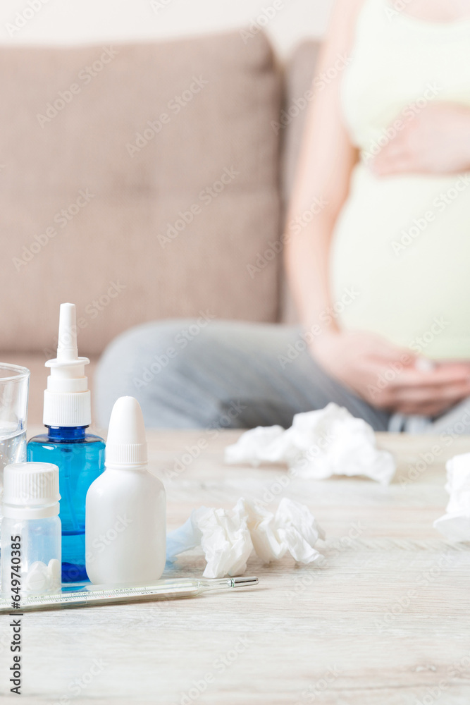 Attractive sick pregnant woman is lying in sofa. Taking pills from colds Attractive sick pregnant woman is lying in sofa. Taking pills from colds