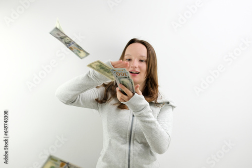 Fotografi Arrogant wealthy girl scattering dollars with proud haughty expression, boasting rich life, throwing around cash, squandering wasting money carelessly