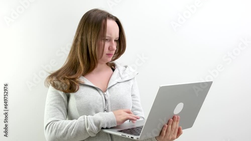 girl angrily dissatisfied typing text on laptop keyboard problems solving trouble unwillingness to study Bad answer texting with friend quarrel on white background in studio gadget teen. adolescence