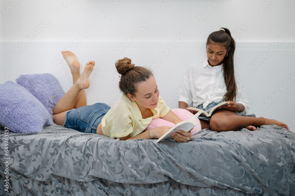 Teenage girls reading books on bed Teenage girls reading books on bed