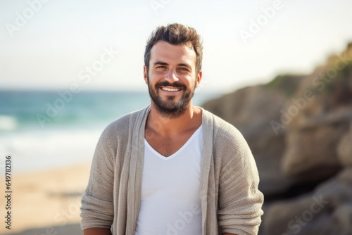 A happy man smiling and laughing by the sea on a sunny day